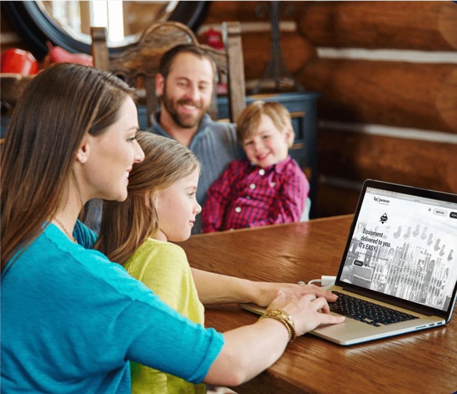 A family booking ski rental on a laptop