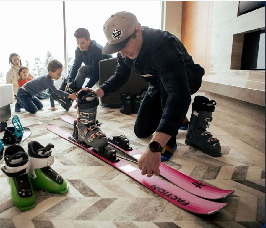 A Top X technician fitting ski boots for a family in their chalet
